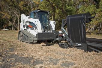 Bobcat compact track loader pulls the silt fence tight using the silt fence installer attachment.