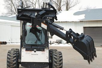 Bob-Tach Backhoe attachment allows a Bobcat skid-steer operator to dump spoil without skidding the loader.