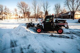 Bobcat snow v-blade attachment for utility vehicles piles snow.