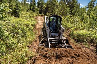 Bobcat compact track loader uses landplane attachment to level black dirt.