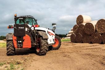 Bobcat VersaHANDLER V723 telehandler and bale fork attachment moving bales. 